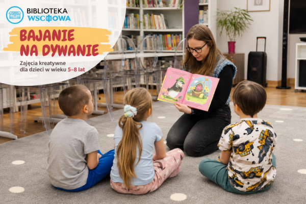Bibliotekarka siedzi na dywanie i czyta ilustrowaną książkę trojgu dzieci podczas zajęć „Bajanie na dywanie” w bibliotece, na tle regałów z książkami i przestrzeni dla najmłodszych czytelników.